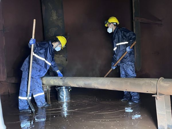 將熱水槽底部污水鏟倒廢桶中，用廢桶搬運出去.jpg