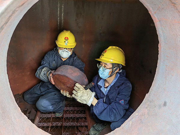 5月11日，動力車間三期工藝除氧器內部，黨員突擊隊隊員劉瑞斌和李震正在清理舊填料.jpg